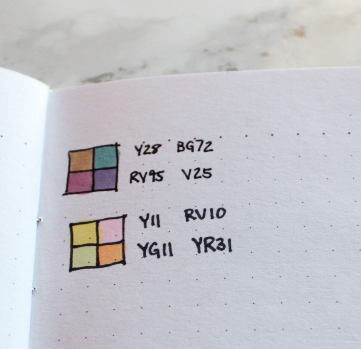 In your bullet journal idea notebook, keep track of color combinations that you like using together, this photograph shows a small grid and Copic color numbers.