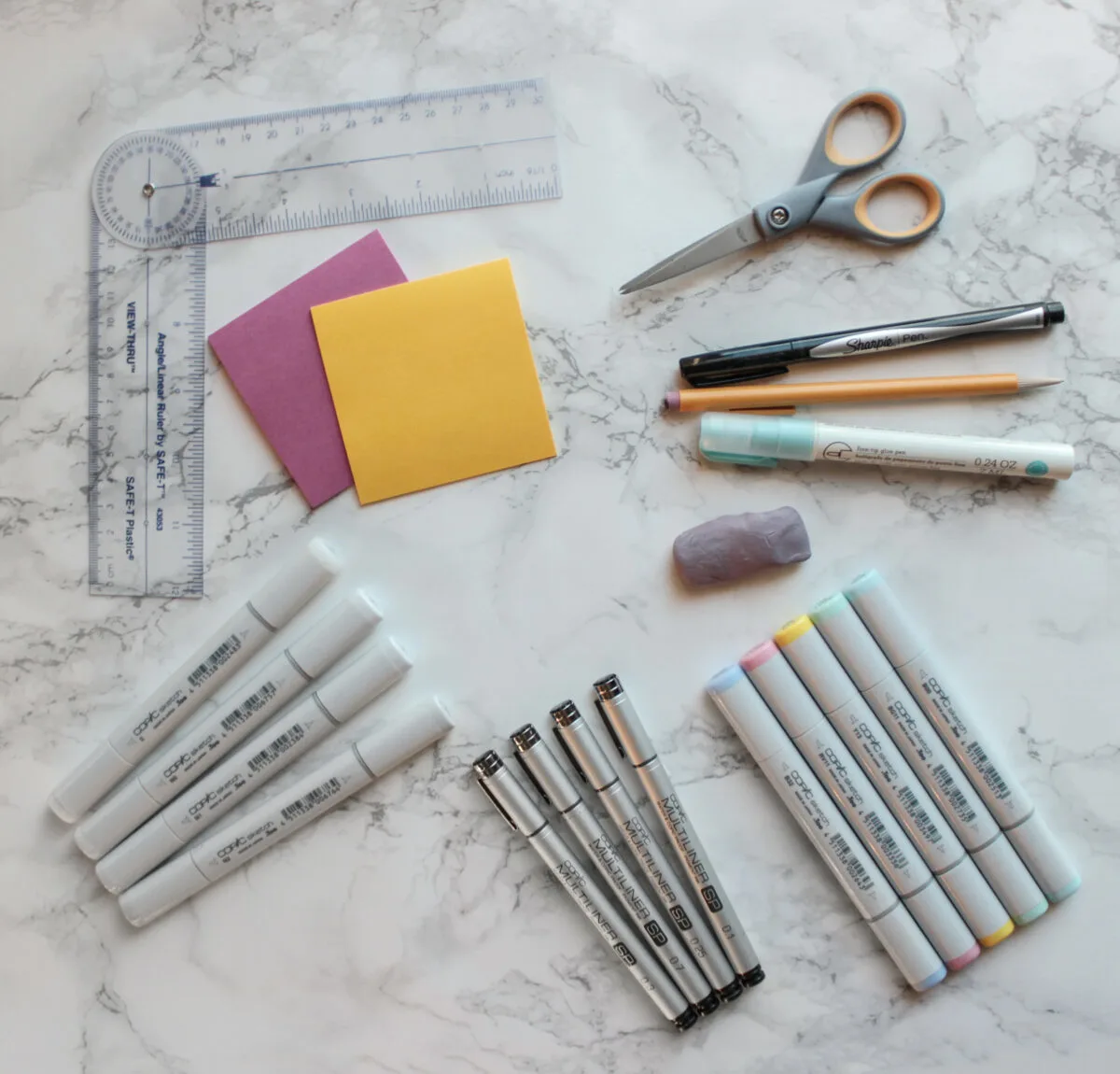 Essential bullet journaling supplies include a pen, ruler, pencil, eraser, gray Copic markers, and mildliner highlighters, all pictured in this photograph.