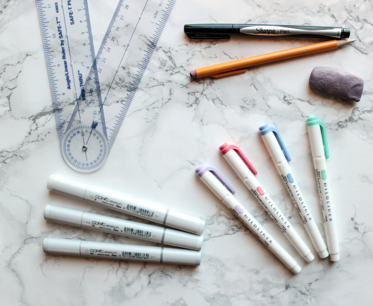 Essential bullet journaling supplies include a pen, ruler, pencil, eraser, gray Copic markers, and mildliner highlighters, all pictured in this photograph.