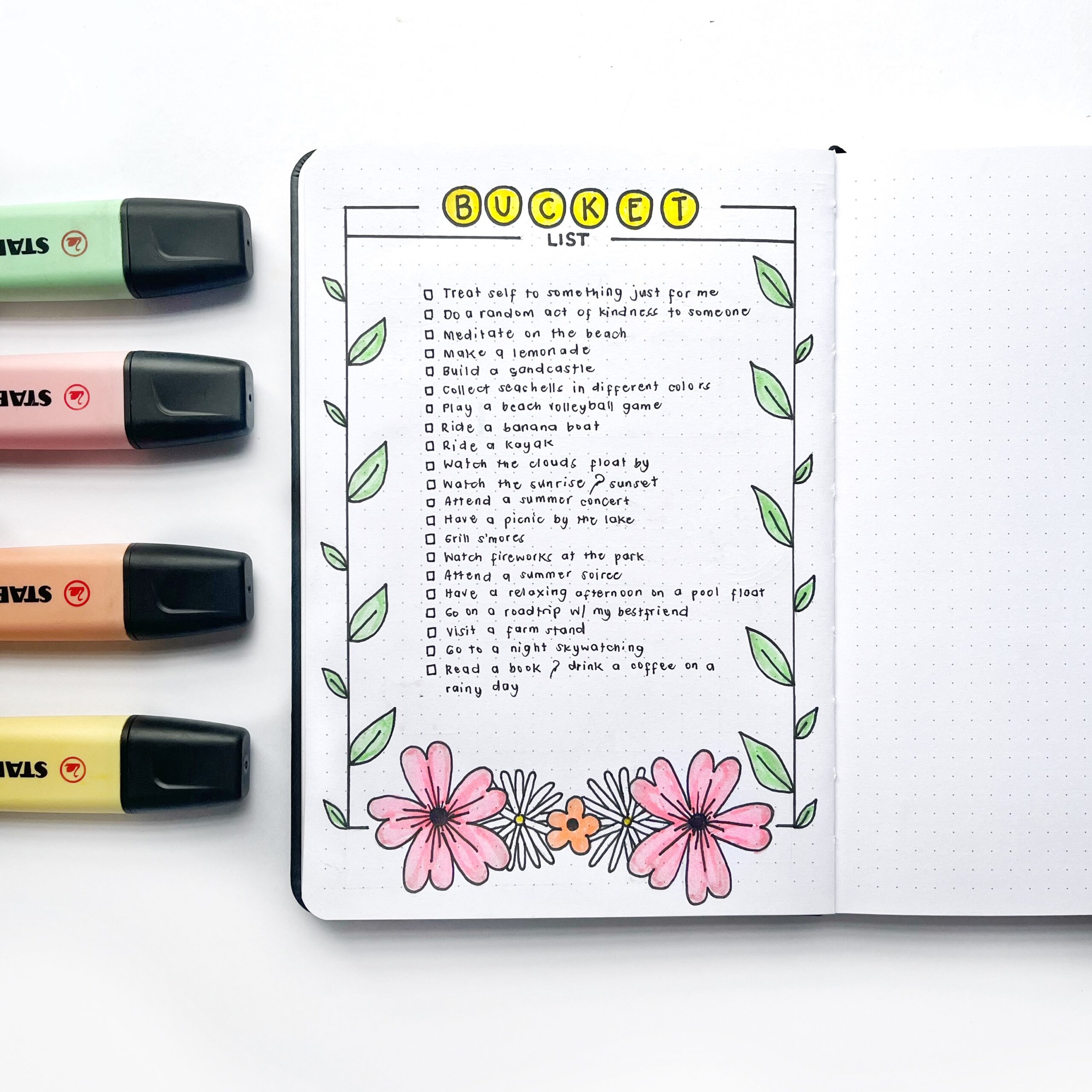 A bullet journal bucket list layout on the page of an open journal.