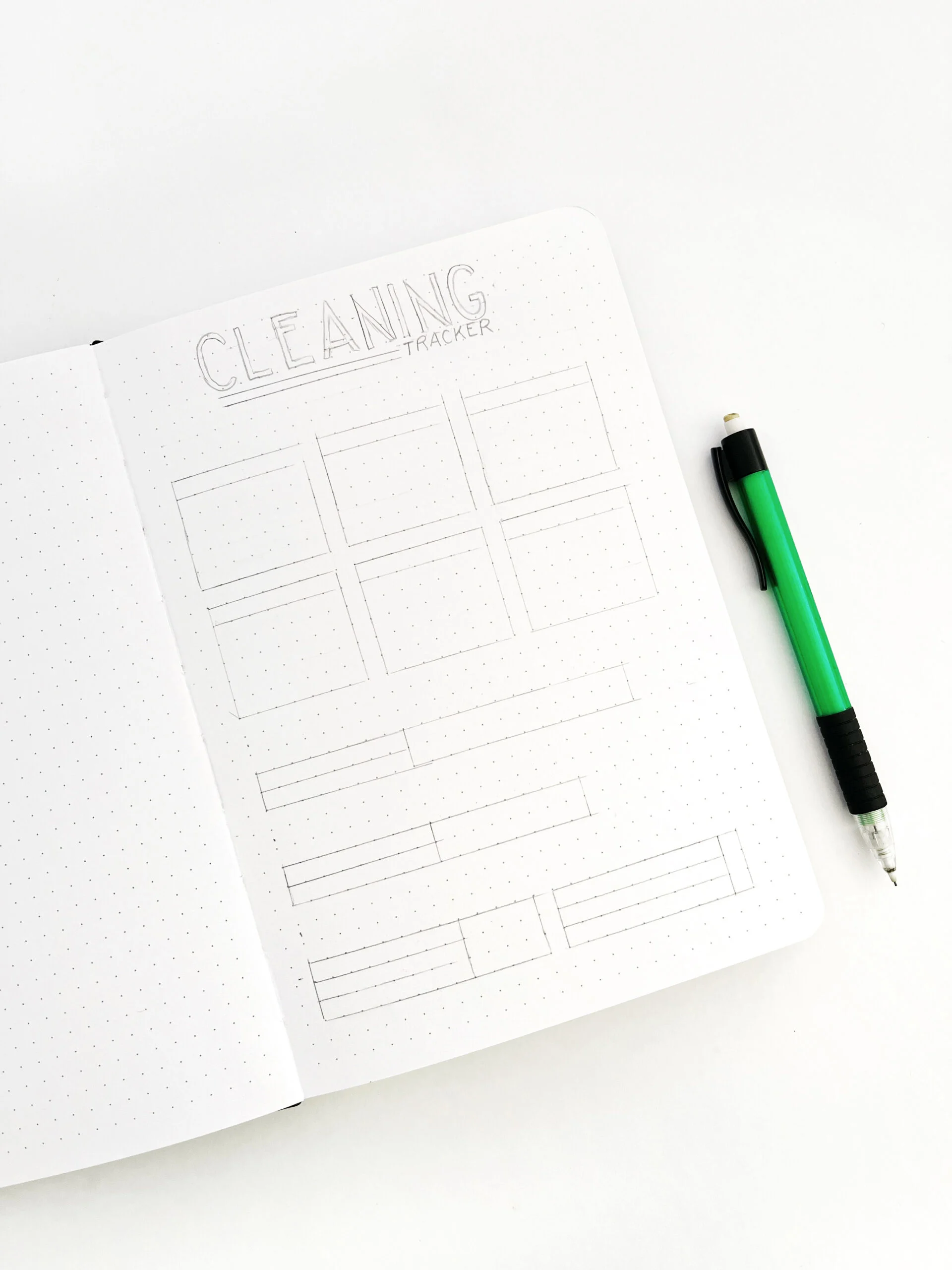 A bullet journal cleaning tracker layout penciled in using grids in a bullet journal.