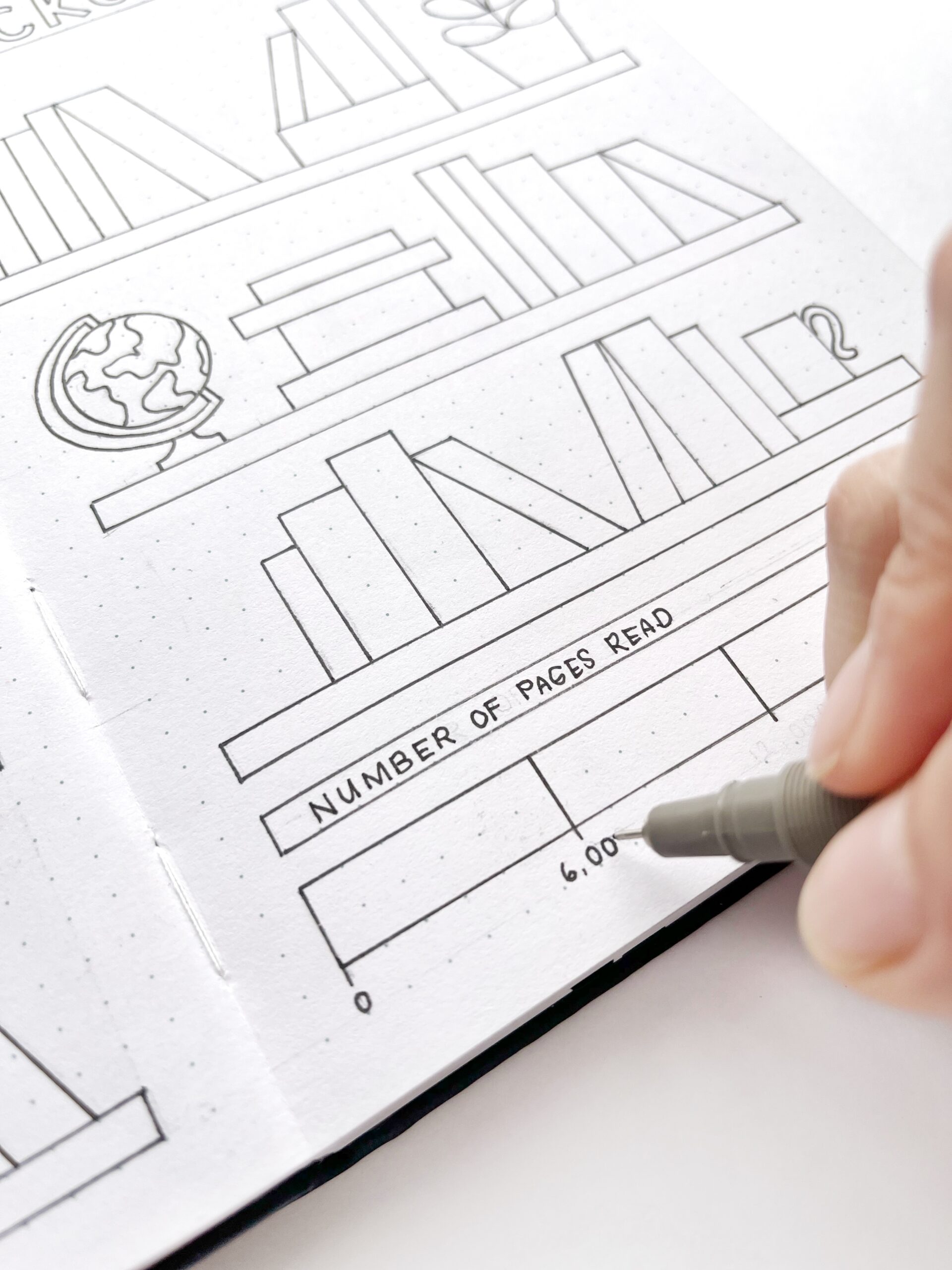 A hand tracing the tracker bar with a pen in the reading tracker layout.