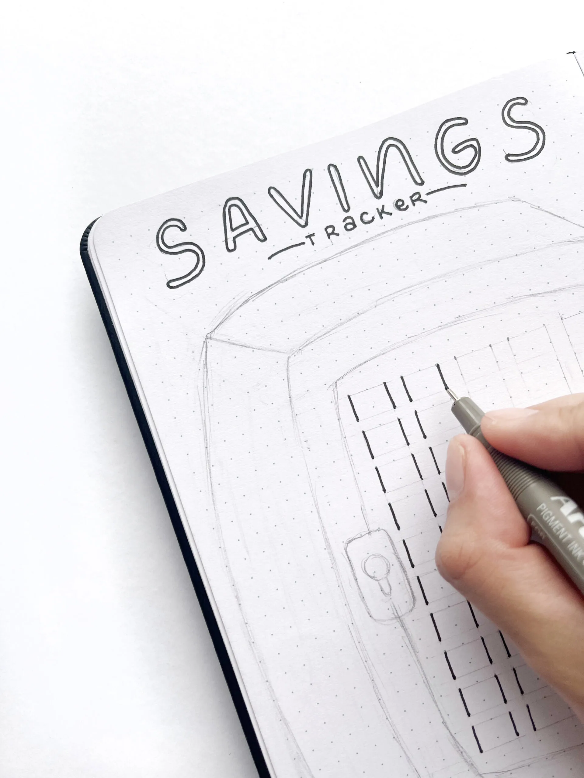 Drawing boxes inside the savings tracker vault with a pen for the bills.